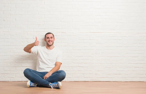 Joven Hombre Caucásico Sentado Suelo Sobre Pared Ladrillo Blanco Que — Foto de Stock