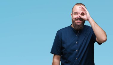 Genç beyaz hipster adam gülümsüyor, parmakları ile mutlu yüz üzerinden seyir göz el ile ok jest yapıyor izole arka plan.