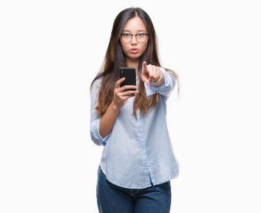 Genç Asyalı kadın kamera için parmak ile işaret izole arka plan üzerinde akıllı telefon kullanma