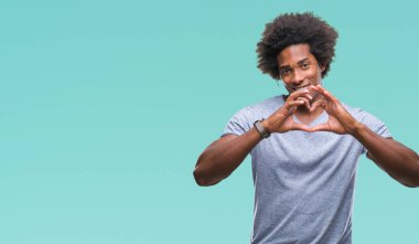 Kalp simgesi ve elleriyle şekil gösterilen aşık gülümseyen izole arka plan üzerinde Afro Amerikalı adam. Romantik kavramı.