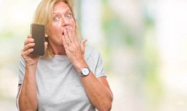 Hata, korku, sessizlik içinde gizli kavramı korkmuş ifade için utanç ile orta yaş sarışın kadın akıllı telefon boş ekran izole arka kapak ağız el ile üzerinden gösterilen şok