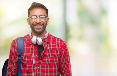 Yetişkin İspanyol öğrenci yüzünde mutlu ve güzel bir gülümseme ile izole arka plan üzerinde giyen kulaklık ve sırt çantası dostum. Şanslı kişi.