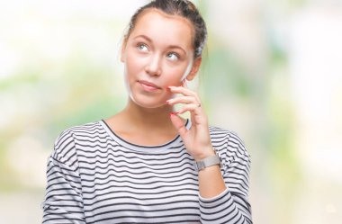 Genç güzel beyaz kadın elle çene düşünme hakkında soru, dalgın ifade izole arka plan yüzünden. Düşünceli yüzüyle gülümsüyor. Şüphe kavramı.