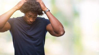 Afro Amerikalı adam çünkü umutsuz ve stresli baş ağrısı acı izole arka plan üzerinde ağrı ve migren. Ellerini kafasına.