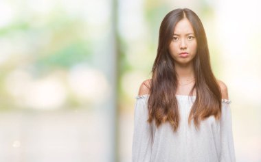 Genç Asyalı kadın izole arka plan şüpheci ve gergin