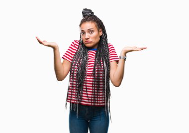 Genç izole arka plan clueless ve şaşkın bir ifadeyle kollar ve eller kaldırdı üzerinde saç Afro-Amerikan Kız örgülü. Şüphe kavramı.