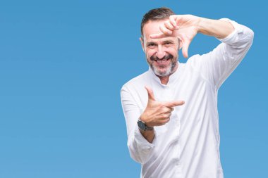 Orta yaş elle yapma çerçeve ve parmakları ile mutlu yüz gülümseyen izole arka plan üzerinde ağarmış komuta sizde. Yaratıcılık ve Fotoğrafçılık kavramı.