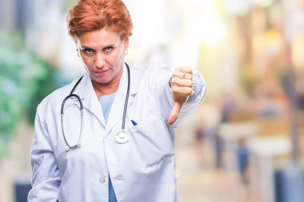 不幸なと怒って拒否反応を示さず ジェスチャーを親指で否定的な分離の背景に医療制服を着て先輩の白人医師女性 不適切な表現 — ストック写真