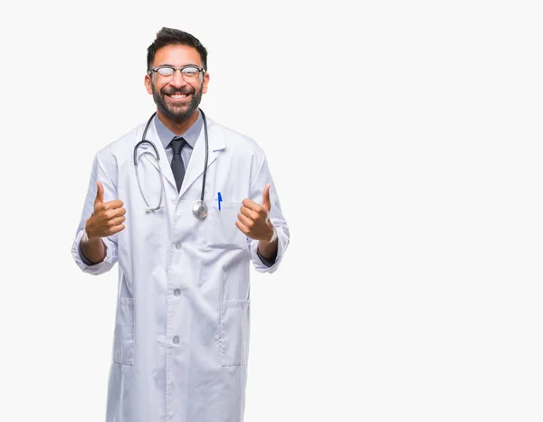 成人西班牙裔医生男子在孤立的背景成功标志做积极的手势与手 竖起大拇指微笑和快乐 用欢快的表情看着相机 胜利者的手势 — 图库照片