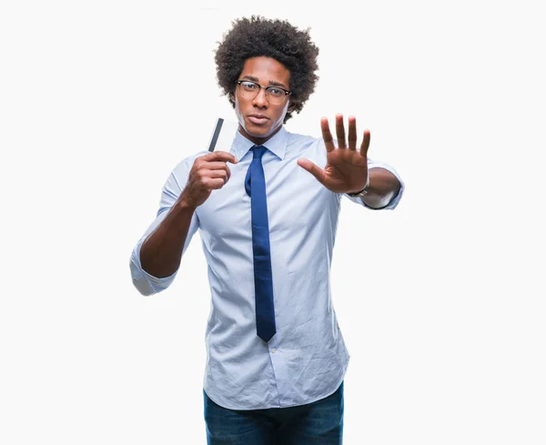 非裔美国男子持有信用卡在孤立的背景下 张开手做停止标志 认真和自信的表达 防御姿态 — 图库照片