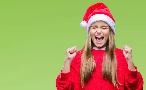 年轻美丽的女孩戴着圣诞节帽子在孤立的背景兴奋的成功与武器举起庆祝胜利微笑 获奖者概念 — 图库照片