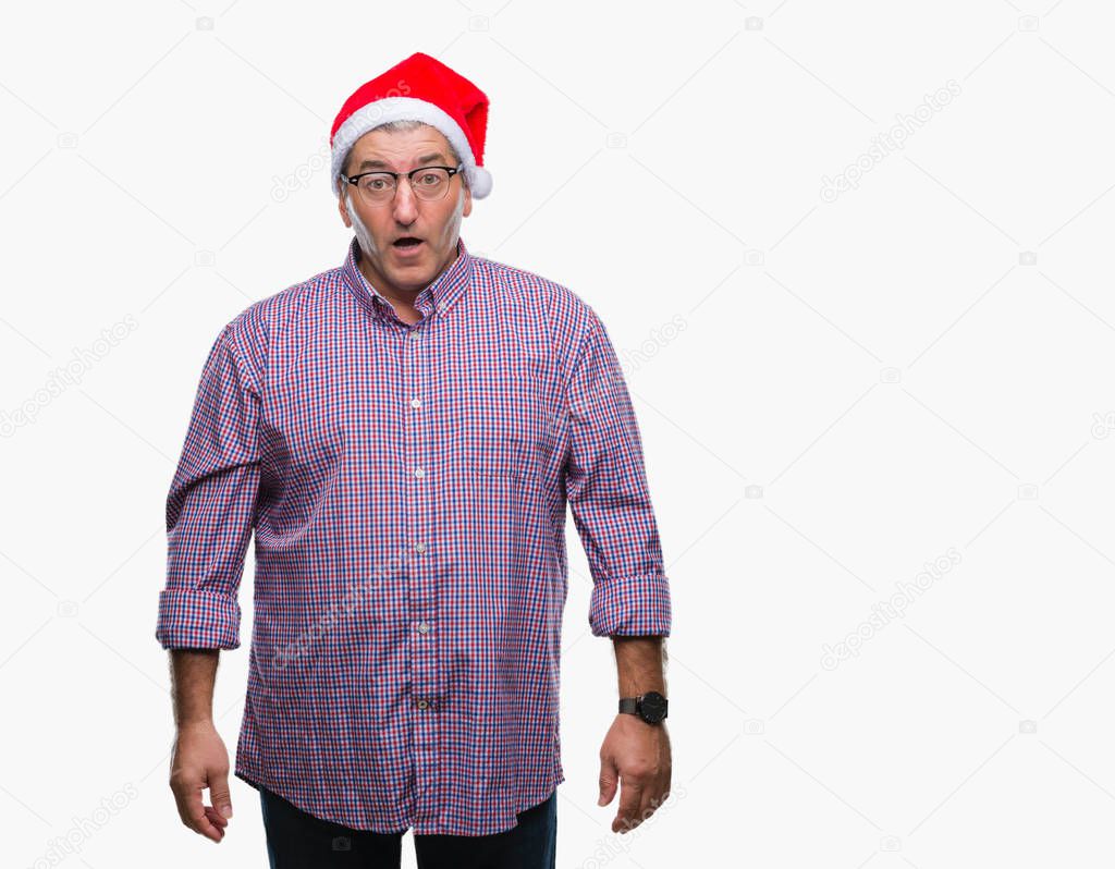 Handsome senior man wearing christmas hat over isolated background afraid and shocked with surprise expression, fear and excited face.