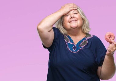 Kıdemli artı boyutu ile izole arka plan üzerinde beyaz kadın yeme şeker çörek vurguladı kafasına, utanç ve sürpriz yüz, öfkeli ve sinirli ile şok ver. Korku ve hata için üzgün.