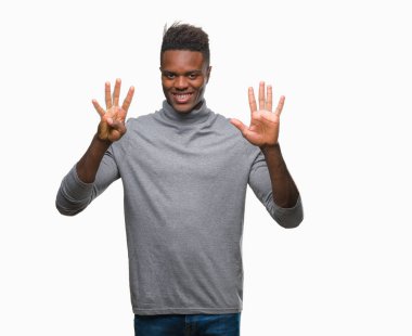 Genç Afro-Amerikan adam gösterilen ve parmakları ile işaret izole arka plan üzerinde numara 9 kendinden emin ve mutlu gülümseyerek süre.