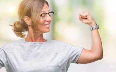 Kol kasları gururlu gülümseyen gösterilen izole arka plan üzerinde gözlük takan orta yaş İspanyol kadın kıdemli. Fitness kavramı.