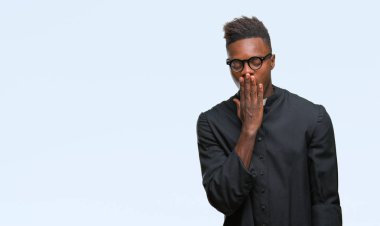 Genç Afro-Amerikan rahip adam izole arka esneme sıkılmış kapsayan ağız el ile yorgun. Restless ve uyku hali.