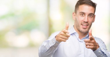 Yakışıklı genç işadamı mutlu ve komik yüzüyle kamerayı işaret ediyor. İyi enerji ve titreşimler.