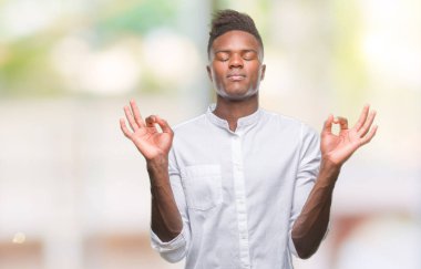 Genç Afro-Amerikan adam izole arka plan üzerinde dinlenmek ve gülümseyen gözlerle parmak ile meditasyon jest yapıyor kapalı. Yoga kavramı.