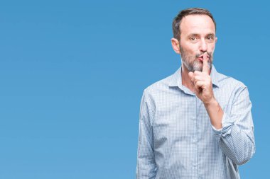 Orta yaş ağarmış üst düzey iş adamı dudaklarında parmak ile sessiz olmanı izole arka plan üzerinde. Sessizlik ve gizli kavramı.
