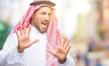 Keffiyeh üzerinde giyen genç yakışıklı adam arka plan korkuyor ve korku ifade dur hareketi el ile ile dehşete şokta bağırarak izole. Panik kavramı.