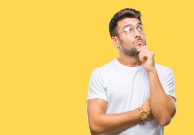 Çene düşünme hakkında soru, dalgın ifade üzerine el ile izole arka plan üzerinde gözlük takan yakışıklı delikanlı. Düşünceli yüzüyle gülümsüyor. Şüphe kavramı.