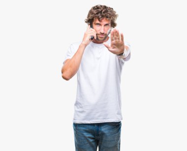 Smartphone ile izole arka plan üzerinde konuşmak İspanyol yakışıklı modeli dur işareti ile ciddi ve kendine güvenen ifade, savunma hareketi yaparken el açmak