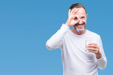 Orta yaş ağarmış komuta sizde mutlu yüz el parmaklarının arasından seyir göz üzerinde ok işaretiyle yapıyor gülümseyen ile izole arka plan üzerinde bardak su içme