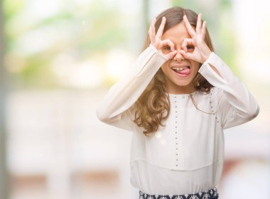 Esmer Latin kız dilini, parmaklarının arasından baktığını yapışmasını dürbün gibi ok jest yapıyor. Deli ifade.