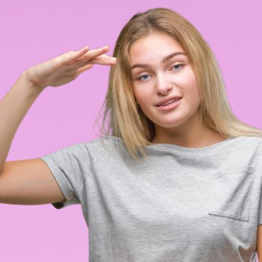 İzole arka plan ile büyük ve büyük boy işaret, ölçü birimi sembol gösteren el eller genç beyaz kadın. Kameraya bakarak gülümsüyordu. Ölçüm kavramı.