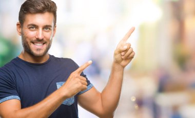 Yakışıklı delikanlı gülümseyen ve iki elleri ve parmakları ile tarafına işaret kamera bakarak izole arka plan üzerinde.