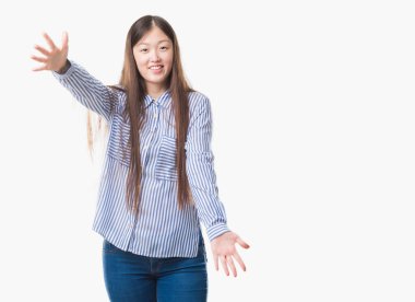 Sarılmak için kollarını açarak gülümseyerek kameraya bakarak izole arka plan üzerinde Genç Çinli kadın. Neşeli ifade kucaklayan mutluluk.