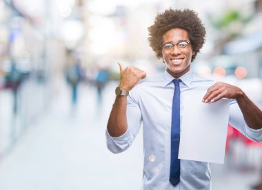 Boş kağıt sözleşme işaret ve başparmak kadar mutlu yüz gülümseyen tarafı ile gösteren izole arka plan üzerinde tutarak Afro Amerikalı adam