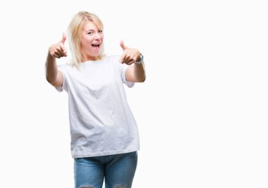 Fotoğraf makinesi ile mutlu ve komik yüz için parmakları işaret izole arka plan üzerinde beyaz t-shirt giyen genç güzel sarışın bir kadın. İyi enerji ve vibes.
