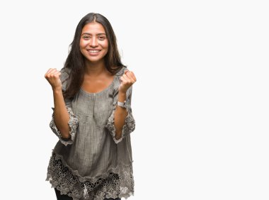 Genç güzel Arap kadın kutluyor izole arka plan üzerinde şaşırttı ve başarı için kaldırdı kollarını açarak hayret ve gözleri açık. Kazanan kavramı.