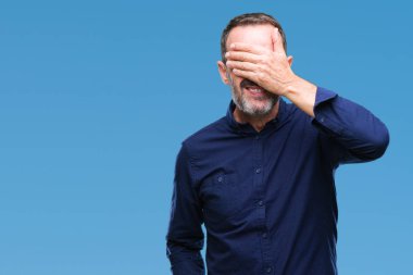 Orta yaş gülümsüyor ve gözleri için sürpriz kapsayan yüz el ile gülüyor izole arka plan üzerinde ağarmış komuta sizde. Kör kavramı.