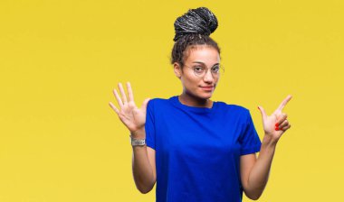 Saç Afro-Amerikan Kız izole arka plan üzerinde gösterilen gözlüklü genç örgülü ve parmakları ile işaret kendinden emin ve mutlu gülümseyerek süre yedi numara.