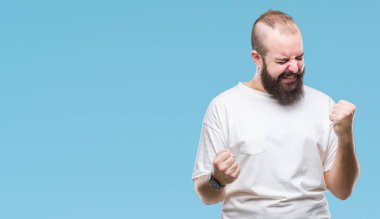 Üzerinde rahat t-shirt giyen genç beyaz hipster adam arka plan çok mutlu ve heyecanlı kaldırdı, silah ile kazanan jest yapıyor gülümseyen ve başarı için çığlık izole. Kutlama kavramı.