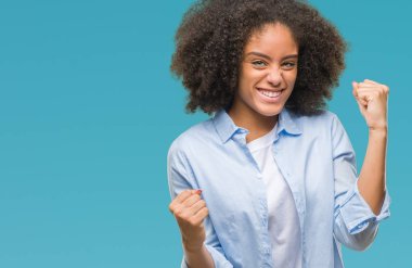 Gülümseyen ve başarı için çığlık genç afro Amerikan kadın izole arka plan çok mutlu ve heyecanlı kaldırdı, silah ile kazanan jest yapıyor. Kutlama kavramı.