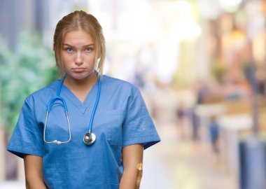 Genç beyaz doktor kadın giyiyor cerrah depresif izole arka plan üzerinde üniforma ve kızgın ve korkmuş ağlıyor sıkıntı için endişeleniyorum. Üzgün ifade.