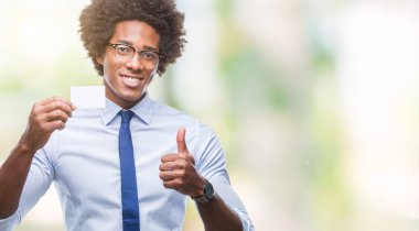 İzole arka plan üzerinde ziyaret Kart ok işareti, başparmak ile parmak, mükemmel işareti yapıyor kocaman bir gülümseme ile mutlu tutarak Afro Amerikalı adam