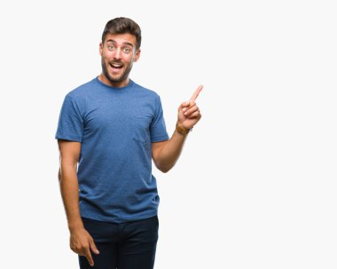 Kameraya bakarak yan el ve parmak ile işaret eden genç yakışıklı adam yüzünde kocaman bir gülümseme ile izole arka plan üzerinde.