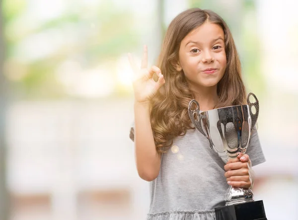 Brunette Hispanic Girl Holding Trophy Doing Sign Fingers Excellent Symbol — Stock Photo, Image