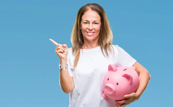 Mulher Hispânica Meia Idade Economizando Dinheiro Usando Mealheiro Sobre Fundo — Fotografia de Stock