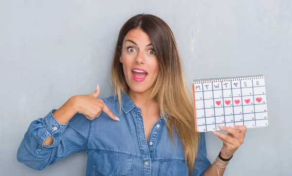 Jovem Mulher Adulta Sobre Parede Grunge Cinza Mostrando Calendário Período — Fotografia de Stock