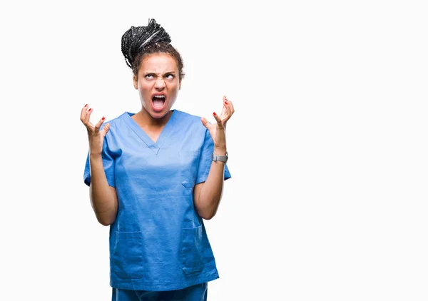 年轻编织头发非洲裔美国女孩专业护士在孤立的背景疯狂和疯狂的喊话和大喊大叫与积极的表情和武器提出 挫折的概念 — 图库照片
