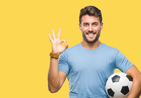 Joven Hombre Guapo Sosteniendo Pelota Fútbol Sobre Fondo Aislado Haciendo —  Fotos de Stock