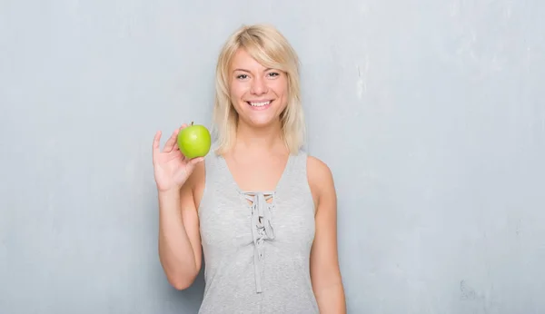 Mujer Caucásica Adulta Sobre Pared Gris Grunge Comiendo Manzana Verde — Foto de Stock