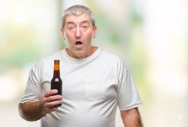 Bonito Homem Sênior Bebendo Garrafa Cerveja Sobre Fundo Isolado Assustado — Fotografia de Stock