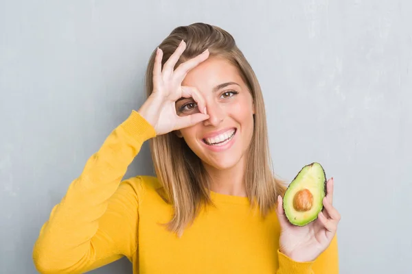 Beautiful Young Woman Grunge Grey Wall Eating Avocado Happy Face — Stock Photo, Image