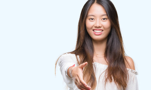 Young asian woman smiling friendly over isolated background
